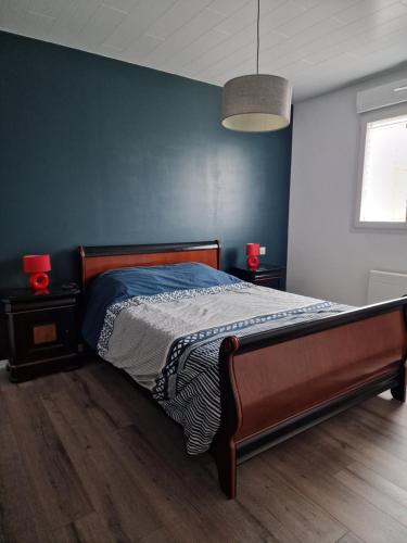 1 dormitorio con 1 cama con pared azul en La Campagne D'ORNANS, 