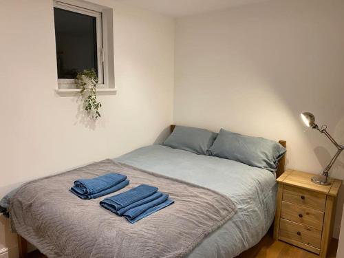 a bedroom with a bed with two blue towels on it at Ashcroft Apartment - Small Home Away From Home in Ashburton