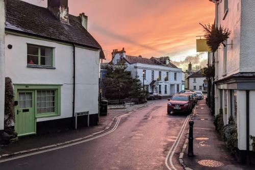 a city street with houses and a car on the road at Hook House in Moretonhampstead