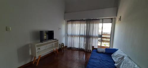 sala de estar con cama y TV en Departamentos San Rafael Mendoza en San Rafael
