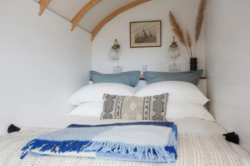a bedroom with two beds with white and blue pillows at The Cabana - a romantic seaside getaway and garden in Ryde