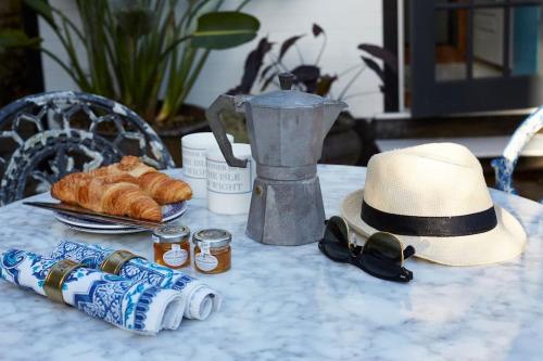 a table with a hat and some drinks and bread at The Cabana - a romantic seaside getaway and garden in Ryde