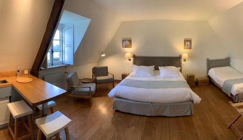 a bedroom with a bed and a desk and a table at Le Domaine de Belleville in Dragey