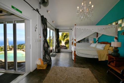 a bedroom with a canopy bed and a pool at Villa Lorizon in Rodrigues Island