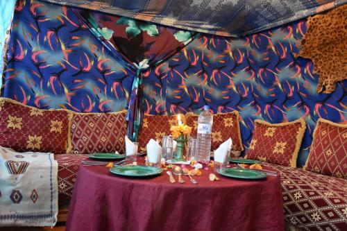 a table in a tent with a purple table cloth at Prends Ton Temps in Zagora