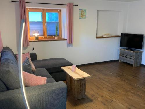 a living room with a couch and a tv at Ferienwohnung "Beim Dôneslar" in Bad Oberdorf