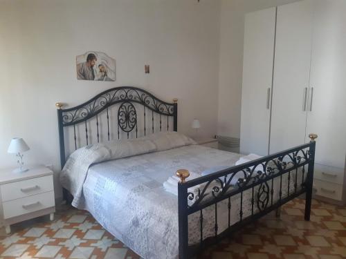 a bedroom with a large bed with a black frame at Appartamento Rosamarina in Torre Lapillo