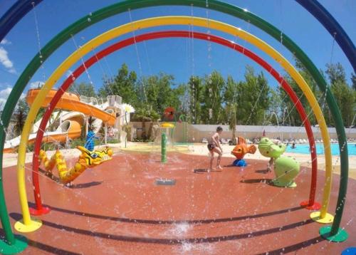 Um rapaz está a brincar num parque aquático. em Mobil Home Palmiers 1 em Valras-Plage