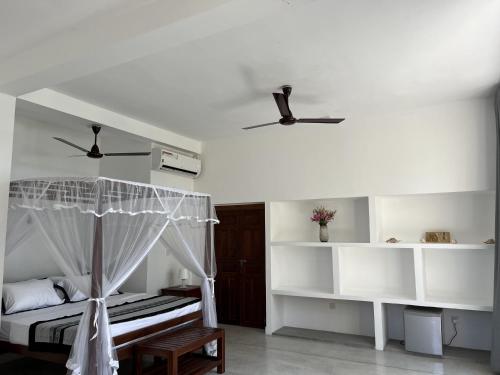 a bedroom with a bed and two ceiling fans at Galawatta Beach Resort in Unawatuna