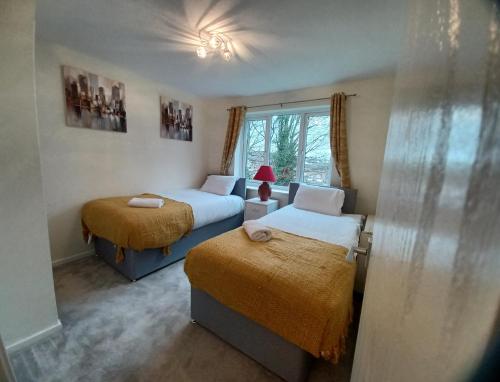 um quarto com 2 camas e uma janela em Huku Kwetu -The Maltings White Door-1st Floor-2 Bedroom Apartment -Self Catering-Quiet- Free Parking em Dunstable