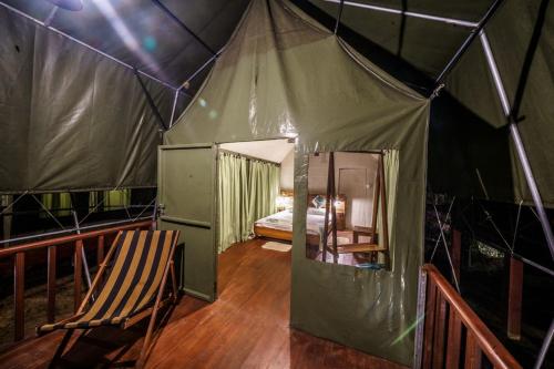 a room with a tent with a bed in it at 360 Rainforest in Deniyaya