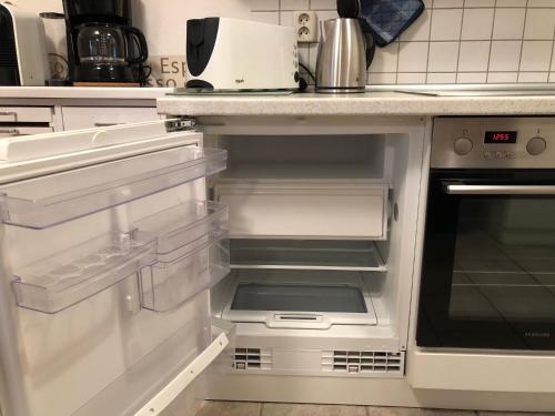einem leeren Kühlschrank mit offener Tür in der Küche in der Unterkunft Darsser Weg 34 in Zingst