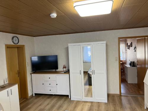 a living room with a television and white cabinets at Bergmannsruh in Clausthal-Zellerfeld