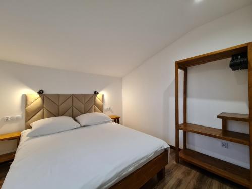 sypialnia z dużym białym łóżkiem i drewnianą podłogą w obiekcie Apartament nad Przykopą w mieście Krempachy