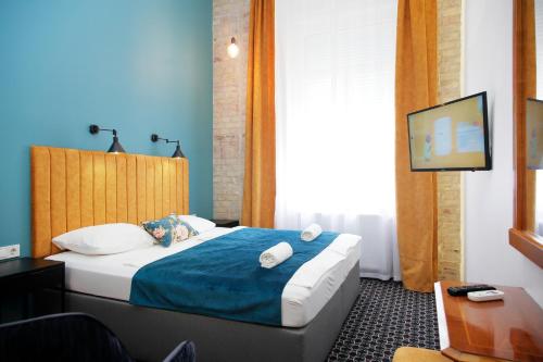 a hotel room with a bed and a tv at Giselle Vintage Doubles - Adults Only in Budapest