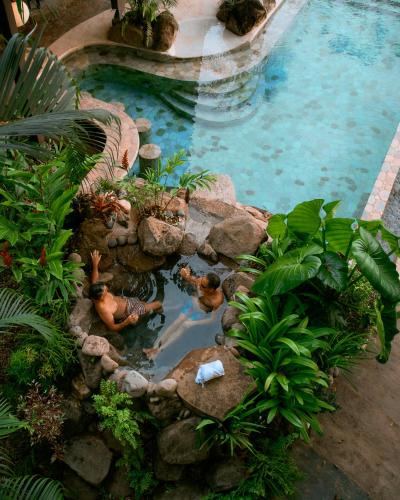 two people swimming in a pool in a garden at Vista Celestial in Uvita