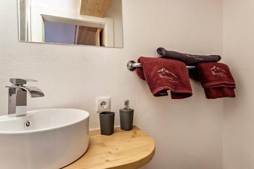 a bathroom with a sink and a mirror and towels at Bergwelt A2 in Niederau
