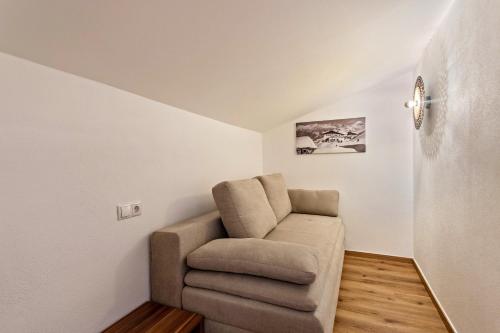 ein Wohnzimmer mit einem Stuhl in der Ecke in der Unterkunft Bergwelt B in Niederau