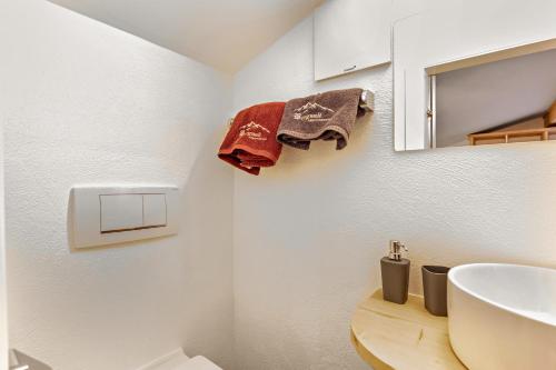 La salle de bains est pourvue d'un lavabo et de serviettes murales. dans l'établissement Bergwelt B, à Niederau