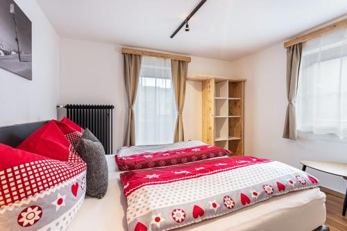 1 Schlafzimmer mit 2 Betten mit roter und weißer Bettwäsche in der Unterkunft Bergwelt A1 in Niederau