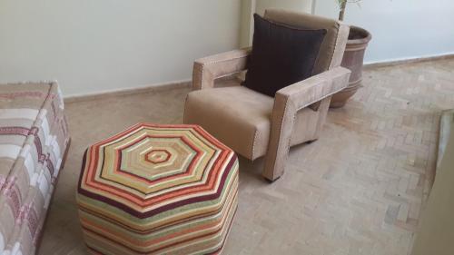 - un salon avec une chaise et un parasol dans l'établissement Riad Maialou & SPA, à Marrakech
