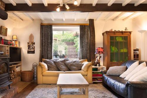 una sala de estar con un sofá y una mesa en La Bergerie, en Gedinne