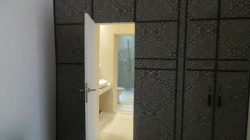 a bathroom with a door open to a bathroom with a toilet at Riad Maialou & SPA in Marrakech