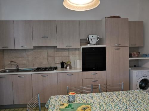 a kitchen with wooden cabinets and a table with a tablecloth at Casa Pipere in Santa Lucia