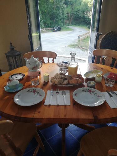 ein Holztisch mit Tellern voller Essen darauf in der Unterkunft Chambre d'hôte Moulin du Breuil. in Pionnat
