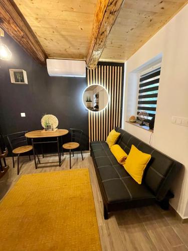 a living room with a black couch and yellow pillows at Molla Villa Kökény in Kökény