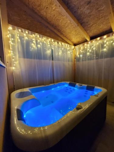 a large blue tub in a room with lights at Molla Villa Kökény in Kökény