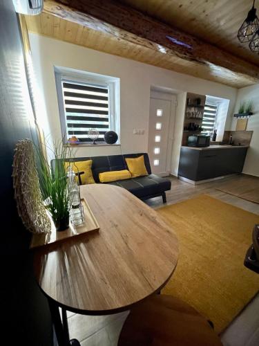 a living room with a wooden table and a couch at Molla Villa Kökény in Kökény