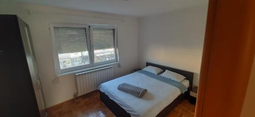 - une chambre avec un lit et 2 fenêtres dans l'établissement Apartman Stella Istočno Sarajevo, à Lukavica