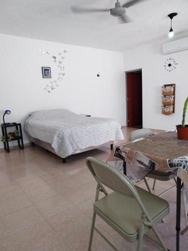a bedroom with a bed and a table and a chair at Sisal Brisa de Mar in Sisal