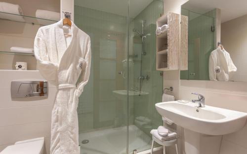 a bathroom with a glass shower and a sink at Hotel Carlton in Tunis