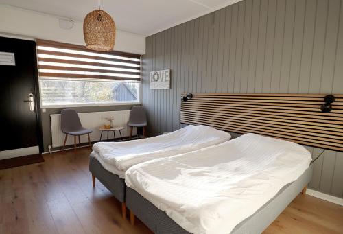 a bedroom with a bed and a table and chairs at Strandmotellet in Greve