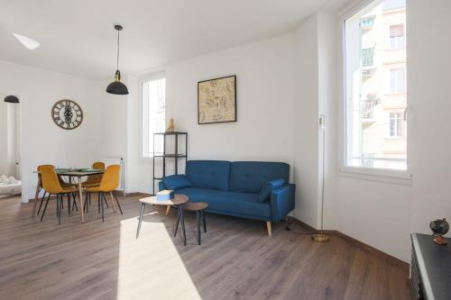 un salon avec un canapé bleu et une table dans l'établissement Appartement Palme d'Or - Welkeys, à Cannes