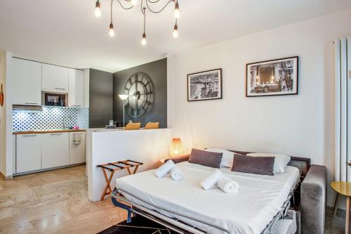 une chambre avec un grand lit dans une pièce dans l'établissement Studio Merle - Welkeys, à Cannes