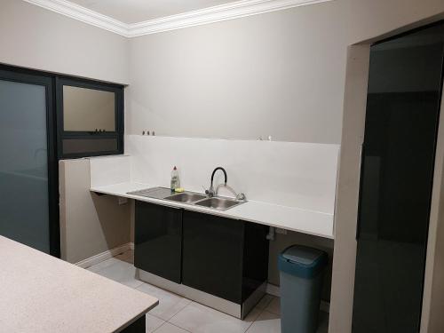 a kitchen with a sink and a counter top at Alcade Ekhaya in Pretoria