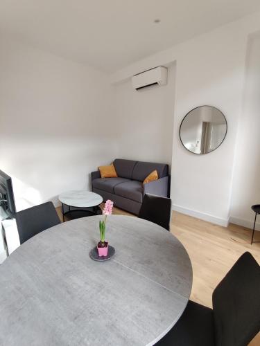 un salon avec une table et un canapé dans l'établissement T2 neuf tout équipé, climatisé, à Marseille