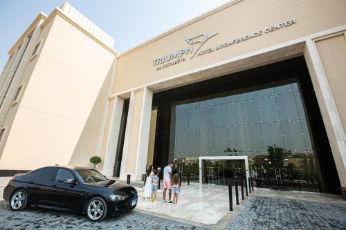 Triumph Luxury Hotel في القاهرة: سيارة سوداء متوقفة أمام مبنى