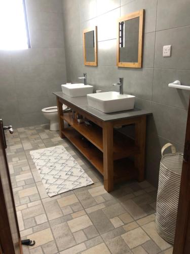 een badkamer met 2 wastafels en een toilet bij Maison familiale à Ile Maurice in Mahébourg