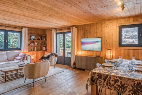 ein Wohnzimmer mit einem Tisch und einem TV in der Unterkunft Appartement Périade - Welkeys in Megève