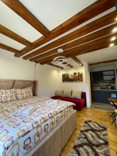 a bedroom with a large bed and a couch at Vila Montenegrina in Kolašin