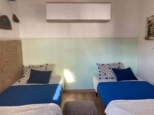 two beds in a room with blue and white at Casa Girassol in Santiago do Cacém