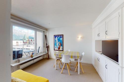 une chambre avec une table, des chaises et une fenêtre dans l'établissement Au Reduit 401, à Saint-Moritz