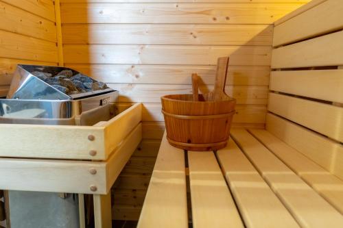 a wooden sauna with a wooden bucket in it at To Je To apartamenty in Maniowy