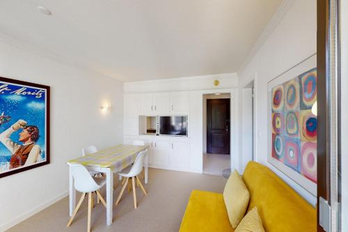 a living room with a table and a yellow couch at Au Reduit 401 in St. Moritz