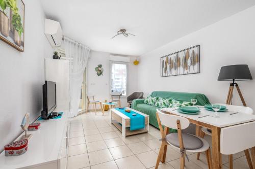 un salon avec un canapé vert et une table dans l'établissement Appartement Libériade - Welkeys, à Cannes