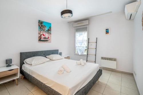 une chambre avec un grand lit blanc avec des serviettes dessus dans l'établissement Appartement Libériade - Welkeys, à Cannes